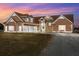 Charming brown two-story home with stone accents, and a spacious three-car garage at dusk at 5949 225Th E St, Bradenton, FL 34211