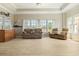 Spacious living room with tile floors, two sofas, large windows, and a ceiling fan at 5949 225Th E St, Bradenton, FL 34211