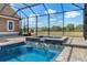 Screened-in pool and integrated hot tub with brick trim offer a relaxing outdoor space at 5949 225Th E St, Bradenton, FL 34211