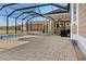 View of covered patio with grill, fans, and pool with a backdrop of outbuildings, lawn, and blue sky at 5949 225Th E St, Bradenton, FL 34211