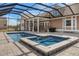 A covered outdoor pool area featuring a hot tub, grill, and stairs to a covered porch at 5949 225Th E St, Bradenton, FL 34211