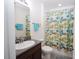 Cozy bathroom featuring granite countertops and a vibrant, patterned shower curtain at 6473 Baytown Dr, Sarasota, FL 34240