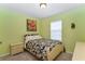 Bright bedroom with light-green walls and tropical-themed accents at 6473 Baytown Dr, Sarasota, FL 34240