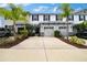 Charming townhome with a two-car garage, palm trees, and beautifully landscaped front yard at 6473 Baytown Dr, Sarasota, FL 34240