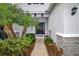 A pathway leading to a lovely front door with a garden featuring palm trees and lush plants at 6473 Baytown Dr, Sarasota, FL 34240