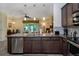 Stylish kitchen with stainless steel appliances, dark cabinetry, and granite countertops overlooking the living area at 6473 Baytown Dr, Sarasota, FL 34240