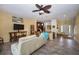 Open-concept living room features a ceiling fan, tile floors, and view into the kitchen at 6473 Baytown Dr, Sarasota, FL 34240
