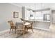 Dining area features rattan chairs, glass table and modern chandelier with views into the open kitchen at 8142 Miramar Way # 71, Lakewood Ranch, FL 34202