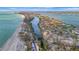 Breathtaking aerial view shows a coastal community with waterfront homes, a beautiful beach, and gorgeous landscaping at 8555 Heron Lagoon Cir, Sarasota, FL 34242