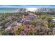 Aerial view of the property showcasing a charming home surrounded by lush landscaping and ocean views at 8555 Heron Lagoon Cir, Sarasota, FL 34242