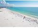 Aerial view of a sandy beach with clear blue water and beachgoers at 8555 Heron Lagoon Cir, Sarasota, FL 34242