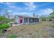 Charming single-story home with a screened-in porch, mature landscaping, and a bright red front door at 8555 Heron Lagoon Cir, Sarasota, FL 34242