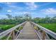 Wooden walkway offering a picturesque path through lush greenery, leading to the water at 8555 Heron Lagoon Cir, Sarasota, FL 34242