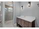 Bathroom with dark wood vanity, quartz countertop, decorative lights, and glass enclosed tiled shower at 9241 Starry Night Ave, Sarasota, FL 34241