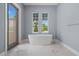 Light and bright bathroom with a free standing tub and marble tile flooring at 9241 Starry Night Ave, Sarasota, FL 34241