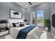Stylishly decorated bedroom with large windows, featuring a white headboard bed and modern art at 9241 Starry Night Ave, Sarasota, FL 34241
