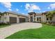 A well-manicured lawn and long driveway lead to this home with a three-car garage at 9241 Starry Night Ave, Sarasota, FL 34241