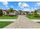 Beautifully landscaped front exterior with a paver driveway leading to an elegant home at 9241 Starry Night Ave, Sarasota, FL 34241