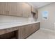 Bright laundry room featuring ample storage, white quartz countertops, and a convenient sink at 9241 Starry Night Ave, Sarasota, FL 34241