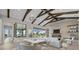 Stunning open-concept living room with exposed beams, modern fireplace, and seamless indoor-outdoor flow at 9241 Starry Night Ave, Sarasota, FL 34241
