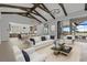 Bright living area with modern decor, white sofas, beamed ceilings and an open kitchen at 9241 Starry Night Ave, Sarasota, FL 34241