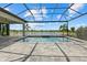 A screened in-ground pool overlooks a picturesque lake framed by palm trees and lush landscaping at 9241 Starry Night Ave, Sarasota, FL 34241