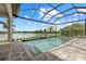 A private in-ground swimming pool with a screened enclosure overlooks a calm lake at 9241 Starry Night Ave, Sarasota, FL 34241