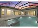 An outdoor area features a luxurious in-ground pool and spa with an outdoor kitchen nearby at 9241 Starry Night Ave, Sarasota, FL 34241