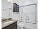 Well-lit bathroom featuring a granite countertop, dark cabinets, and tiled shower with grab bars at 9914 Craftsman Park Way, Palmetto, FL 34221
