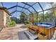 Screened-in patio features a large hot tub with steps and a water feature, alongside brick planters at 9914 Craftsman Park Way, Palmetto, FL 34221