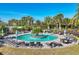 Relaxing community pool area featuring lounge chairs, palm trees, and a center island at 9914 Craftsman Park Way, Palmetto, FL 34221