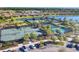 Aerial view of tennis and pickleball courts, parking lot, and surrounding lake with residential houses at 9914 Craftsman Park Way, Palmetto, FL 34221