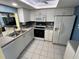 Well-lit kitchen featuring white cabinetry, white appliances, modern countertops, and tiled floor at 1007 Pussywillow Ln, Bradenton, FL 34208