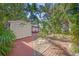 Inviting backyard path surrounded by lush tropical plants and brick pavers at 107 Nippino W Trl, Nokomis, FL 34275