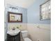Charming bathroom with a pedestal sink, tiled walls, and blue accent paint at 107 Nippino W Trl, Nokomis, FL 34275