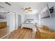 Bright bedroom with hardwood floors, ceiling fan, and mounted TV at 107 Nippino W Trl, Nokomis, FL 34275