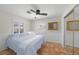 Bright bedroom featuring tile floors, shuttered windows, and a ceiling fan at 107 Nippino W Trl, Nokomis, FL 34275