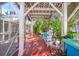 Beautiful covered patio with seating, a table, and lush tropical greenery at 107 Nippino W Trl, Nokomis, FL 34275