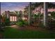 Charming home featuring a stucco exterior, red tile roof, and lush landscaping at 107 Nippino W Trl, Nokomis, FL 34275