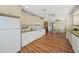Well-lit kitchen boasts wooden floors, white cabinetry, modern appliances and a charming adjacent dining area at 107 Nippino W Trl, Nokomis, FL 34275