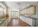 Well-lit kitchen with white cabinetry, wood floors, and modern appliances at 107 Nippino W Trl, Nokomis, FL 34275