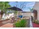 Outdoor patio featuring dining furniture and landscaping under the shade of a patio umbrella at 107 Nippino W Trl, Nokomis, FL 34275