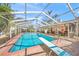 Inviting pool area with diving board and screened enclosure at 107 Nippino W Trl, Nokomis, FL 34275