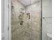 Modern shower with glass door, decorative tile, and built-in storage at 107 Nippino W Trl, Nokomis, FL 34275