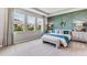 This primary bedroom features three windows, a decorative wall, and dual nightstands with lamps at 10713 Tippecanoe Pl, Parrish, FL 34219