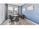 Stylish office space features modern gray wood flooring and a blue accent wall, providing a professional and comfortable workspace at 10713 Tippecanoe Pl, Parrish, FL 34219
