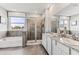 A bright and airy bathroom showcasing a double vanity, granite countertops, shower, bathtub, and a window at 10717 Tippecanoe Pl, Parrish, FL 34219
