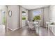 A dining room with neutral paint, natural light from two windows and a modern white round table at 10717 Tippecanoe Pl, Parrish, FL 34219