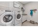 The laundry room boasts a modern washer and dryer with a shelf and counter space at 10717 Tippecanoe Pl, Parrish, FL 34219
