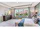 This cozy main bedroom offers three windows, a bench at the foot of the bed and an area rug at 10717 Tippecanoe Pl, Parrish, FL 34219